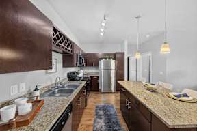 A kitchen with brown cabinets and granite countertops.
