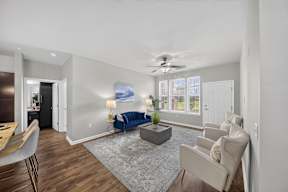 A living room with a blue sofa and a grey rug.