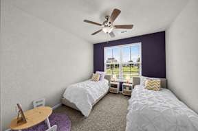 A bedroom with two beds and a ceiling fan.