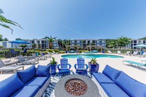A pool area with blue couches and chairs.
