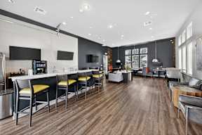 A modern kitchen with wooden floors and a bar area.