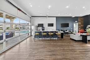 A modern kitchen and dining area with a wooden floor and a balcony with a glass railing.