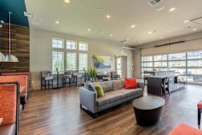 A living room with a grey couch and a wooden floor.