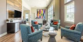 A living room with a large painting on the wall and a TV on the counter.