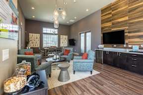 A living room with a wooden floor and a television on the wall.