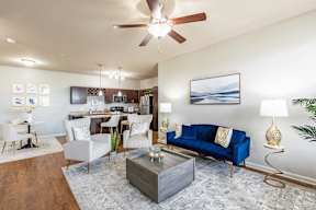 A living room with a blue couch and a wooden coffee table.