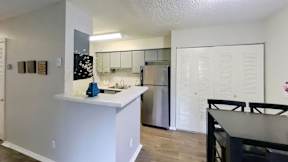 A kitchen with a white counter and a refrigerator.