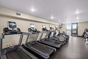 A row of treadmills are lined up in a gym.