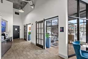 A modern office lobby with a blue chair and a black door.