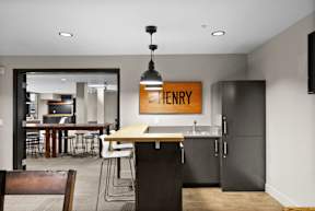 A kitchen with a table and chairs and a framed sign that says Henry.