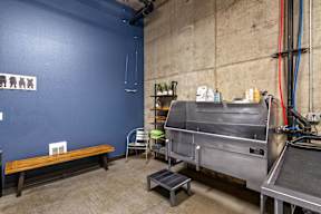 A blue wall with a bench and a machine.