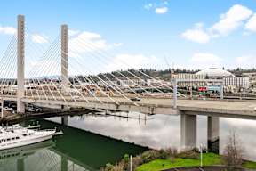 A bridge over a body of water with a boat underneath it.