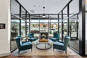 A glass-walled room with a table and chairs in the foreground.