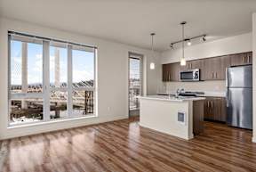 A kitchen with a large window overlooking a marina.
