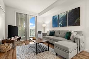 A living room with a grey couch and a coffee table.