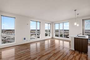 A room with wooden floors and a large window overlooking a snowy landscape.