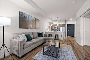 A modern living room with a grey sofa and a coffee table.