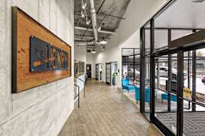 A hallway with a wooden sign that says "The Entrance" on it.