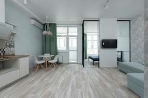 A modern living room with a dining table and chairs.