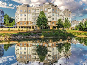 A large building with a pond in front of it.