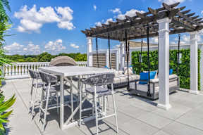 A patio with a table and chairs under a pergola.