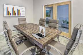 A conference room with a table, chairs, and a chart on the wall.