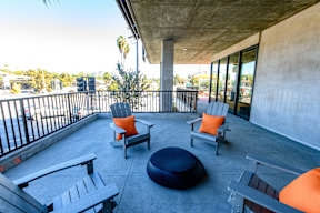 A patio with a black railing and a concrete floor.