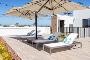 A patio with a table and chairs under an umbrella.