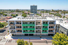 A large white building with green stripes on the windows and balconies.
