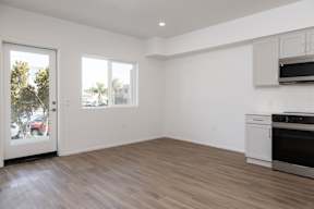 A kitchen with a white oven and microwave built into the cabinetry.