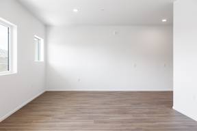 A room with wooden flooring and white walls.