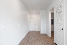 A long white hallway with wood floors and white walls.