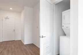 A white door is open to a room with a washing machine.
