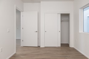 A room with two white doors and a window.