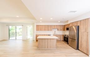 A modern kitchen with wooden cabinets and stainless steel appliances.