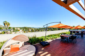 A patio with a table and chairs overlooking a cityscape.