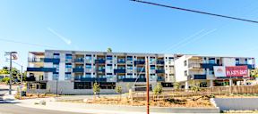 A modern apartment building with a clear blue sky above it.