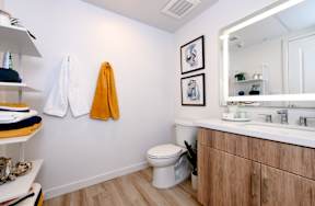 A bathroom with a toilet, sink, and towel rack.