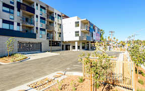 A modern apartment complex with a parking lot in front.