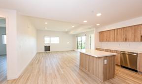A kitchen area with wooden floors and a white countertop.