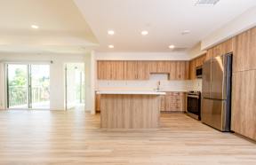 A kitchen with wooden cabinets and a refrigerator.