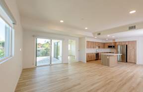 A modern kitchen with wooden floors and a large island.