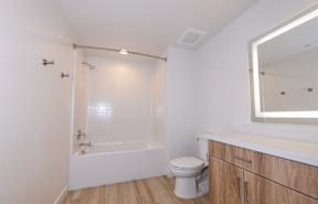 A white bathroom with a toilet, sink, and bathtub.