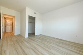 A room with a white wall and wooden flooring.