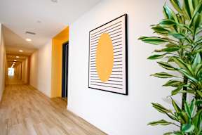 A hallway with a yellow and black picture on the wall.