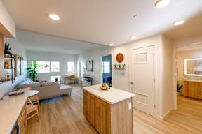 A kitchen with a wooden island and a dining table with chairs.