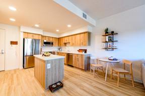 A kitchen with wooden floors and a white ceiling.