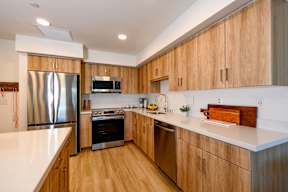 A modern kitchen with wooden cabinets and stainless steel appliances.