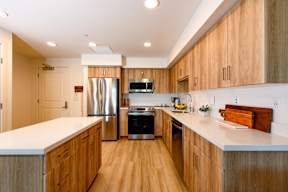 A kitchen with wooden cabinets and a white counter top.