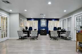 A room with a desk and chairs in it.